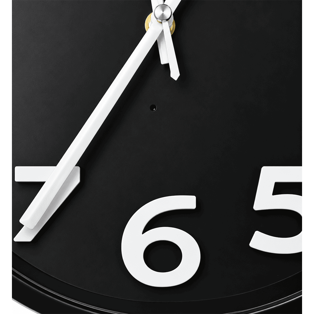 Close-up of discreet camera lens built into black wall clock face