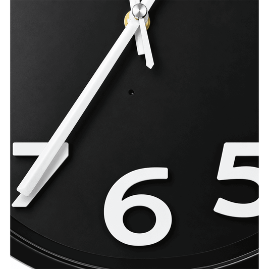 Close-up of discreet camera lens built into black wall clock face